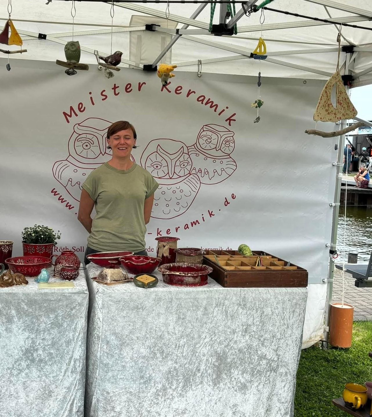 Keramikerin an ihrem Marktstand mit handgemachter Keramik