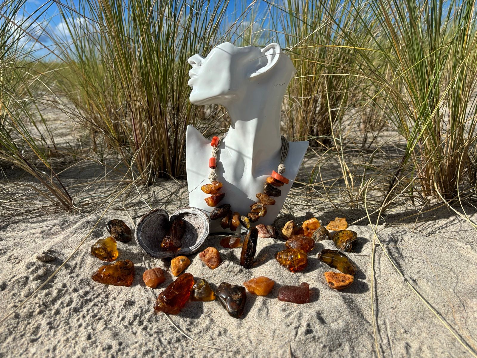 Rohbernstein und Bernsteinschmuck im Sand