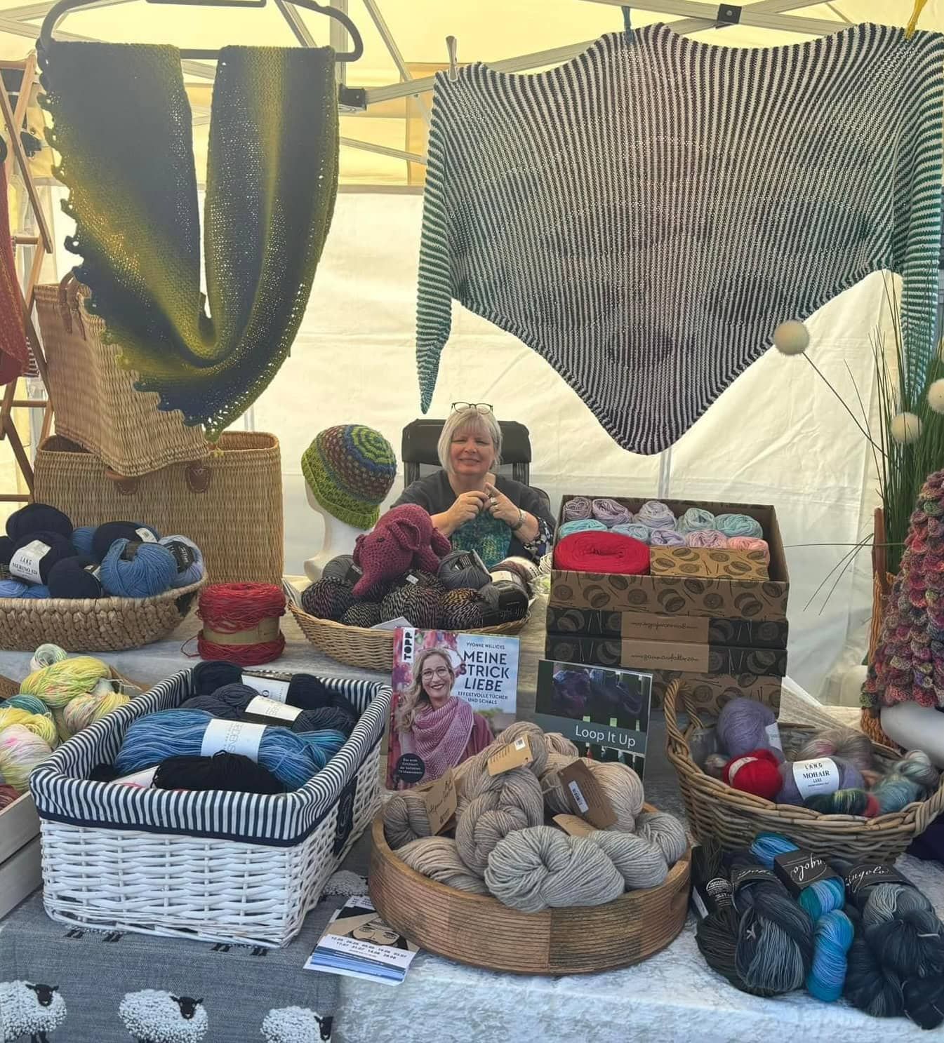 Marktstand mit handgearbeiteten Textilien und Wolle